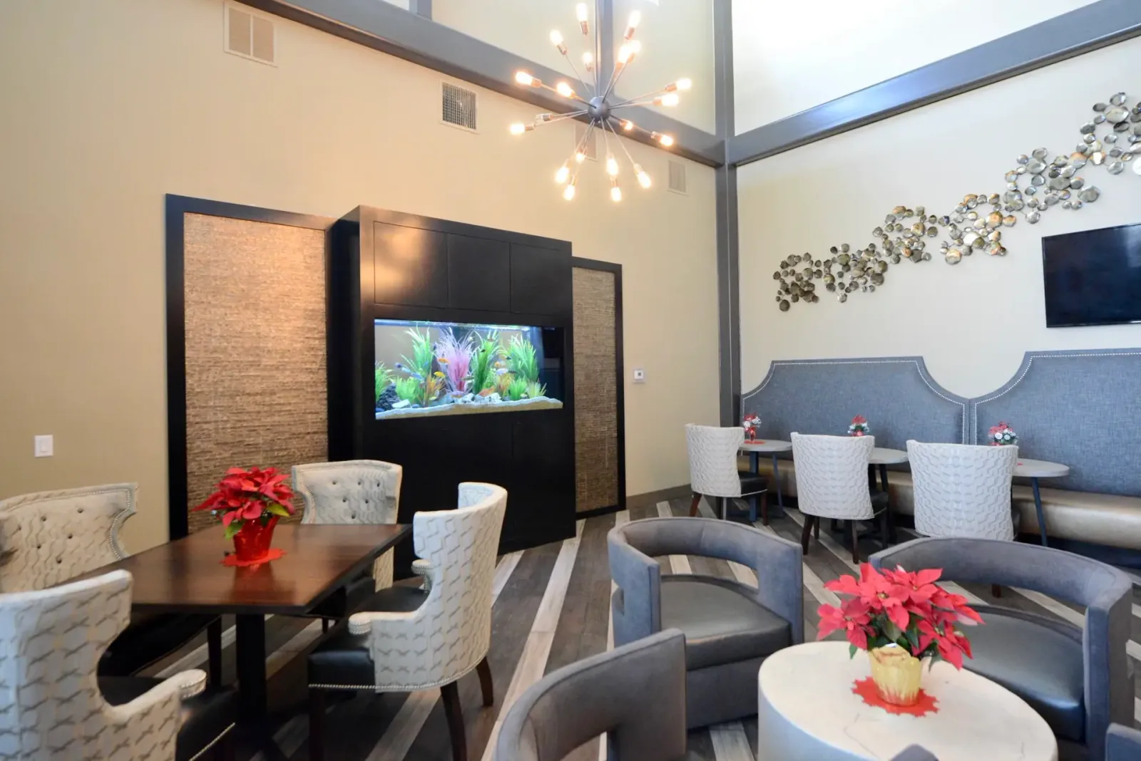 A planted aquarium dividing a bright lounge and dining space.